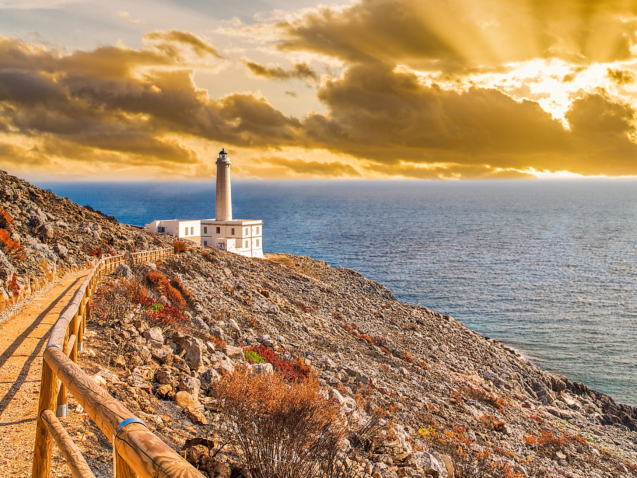 sunrise on the lighthouse of Cape of Otranto in Puglia standing on hard granite rocks